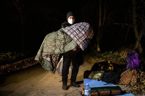 Iraqi father holding his child covered with a sleeping bag which they received from the Polish volunteers (from the NGO Fundacja Ocalenie) supporting migrants at the border. A family of 13 Iraqi Kurds including 4 children asked for asylum in Poland. The family was taken by the Polish border guards back to emergency state zone at the Belarusian border. On the next day, they sent their location indicating that were back on the Belarusian side of the border.