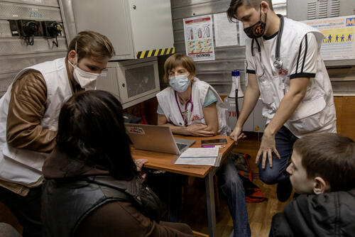 Ludmilla, 40-years-old and her son Vladislav, 11-years-old, are being checked by Kirill, Kelly and Grisha from MSF in a metro station in Kharkiv, Ukraine, on April 11, 2022. 

Ludmilla used to be a refueling operator before the war, in the sourroundings of Kharkiv city. For two weeks, she stayed home under the bombings, but one day, a loud eplosion was too close and she came to live in the subway. 

"I was very scared and worried for my child when I saw him presing our cat on his chest, saying : mommy, I don't want to die."

Until the last second, they hesitated with her family between going abroad or staying : "But Kharkiv is our city, we need to stay, and we need to stay together," she says. So they moved with her mom, husband and son. 

"All the cold, the bad sleep, it is nothing compared to the war," she says. "At least we feel safe here."

She came to see MSF because of knee problems that have started around a year before. She had done all the tests in December, and had an operation planned for the end of February, but then the war started. "Running while coming her eI urt myself even more," she says, hoping to get some painkillers.