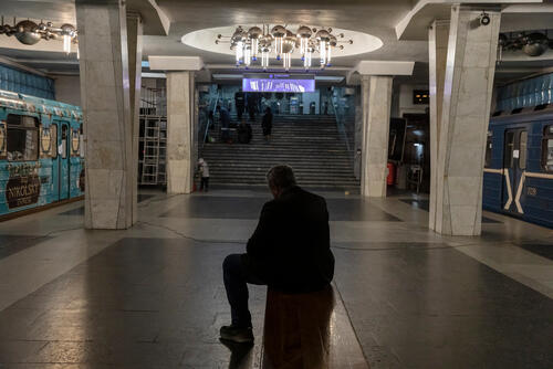 A man sits on a metro bench, between wagons where people now live, hiding fromthe shelling, in Kharkiv, Ukraine, on April 11, 2022.