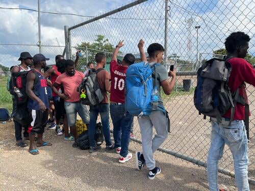 A group of migrants waits for a bus to leave the San Vicente immigration station, in Panama.