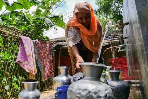 A Rohingya woman fills a pot with drinking water at a water point in Kutupalong-Balukhali camp in Cox’s Bazar district, Bangladesh
