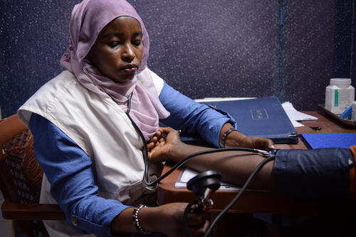Nemat Abaker, MSF midwife supervisor in the maternity ward doing consultations for pregnant women in MSF fixed clinic in El Geneina, West Darfur. The majority of our patients come from the more than 100 sites in the state capital more than 100,000 people displaced people have taken shelter following episodes of deadly violence earlier this year. Water and sanitation conditions in these sites are very poor, contributing to poor health. 
(Written consent)  

 Testimony: 
“We provide reproductive healthcare for women, and we assist them during deliveries. We also provide all prenatal and postnatal care for the mothers. Usually, we receive more than 40 women and assist 5 deliveries a day in the clinic. 

Recently, we started to see fewer patients coming to us because of the recent violence here in El Geneina and attacks on the hospitals which lead to forcing these facilities to close its doors to patients. 

Even before these difficulties, women who face very critical conditions prefer to give birth at home and risk complications rather than going to a hospital. Even if it means a higher risk of dying during childbirth. There are many internally displaced people here and they are living in harsh living conditions which also brings bad consequences for women’s health and wellbeing  

Most of the time mothers come alone without a caretaker and they are in a bad nutrition condition, carrying the responsibility and care for their whole family.” (June 2022)  

 “I am very happy to be a woman and I thank God for creating me as a woman. However, many women in Sudan struggle. They work very hard to feed their children. Even when they are pregnant, they go out to work and get called out by people telling them they should stay home and care for their children. Some girls get married as early as 14 years old and are prevented education, because an educated woman would be strong and resist.   

In the MSF fixed clinic in El Geneina, Western Darfur, we see the many challenges women face to seek medical services. There are lots of displaced people in the city. Some pregnant women come for a first visit and would not come back for the next. Even if our services are free of charge, some women tell us: “I have nothing to eat, how can I come to you again?” Many pregnant women come alone to the clinic, there is no caretaker for them. Even after deliveries, husband usually don’t come. In another MSF clinic here in Darfur, we saw a girl who had gone through an unsafe abortion, she had severe anaemia. She spent three days without nobody asking about her. It is a neighbour who saw her by chance in the hospital and alerted the husband. Why did he not come with her?   

When I was a young student, I saw a woman die while giving birth, because of a lack of medical care. She had been delivered by a traditional birth attendant. At that moment, I decided to complete my education in order to avoid this to happen again. With MSF I can keep learning and achieving this. Helping mothers and their babies is the most important thing for me. I hope to learn more, know more, help more.” (March 2022)