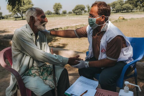 Dr Mohsin telling an elderly patient not to worry about his diagnosis, as the MSF mobile clinic will provide him with treatment and medication, Alladad village, Dadu district, Sindh