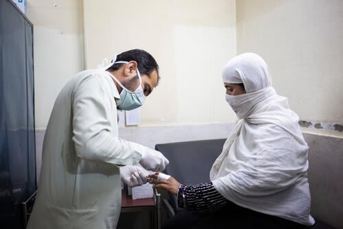An MSF medical technician is applying a bandage on the lesion of Gulnaz’s finger. The bandage will keep the lesion clean and protected. She is receiving treatment for cutaneous leishmaniasis (CL) skin disease at MSF’s CL centre at treatment for Naseerullah Khan Babar Memorial Hospital in Peshawar, Khyber Pakhtunkhwa province Pakistan, on 26 May 2022.