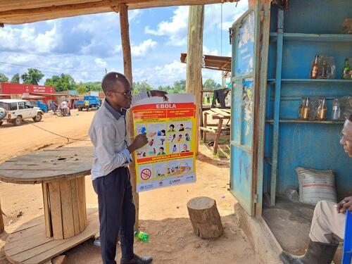 An MSF health promoter talks with a shop keeper in Madudu, close to the epicentre of the Ebola outbreak in Uganda.