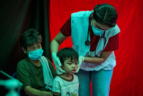 Agustina watches as Trisha Thadhani, MSF TB doctor, conducts a medical evaluation of her grandson Ion, at one of MSF's active case finding sites for tuberculosis on March 13, 2023 in Tondo, Manila, Philippines.