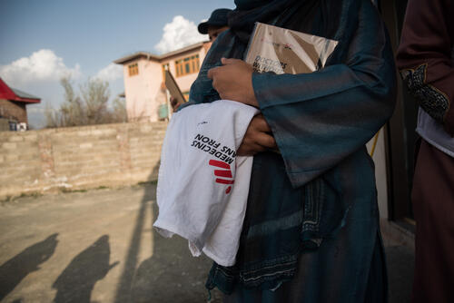 Community Mental Health worker holding MSF jacket and planner.​