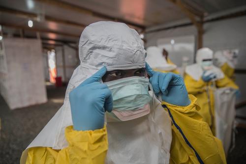 An MSF nurse checks her PPE in the mirror as she prepares to enter MSF's Ebola treatment center in Freetown, Sierra Leone.
