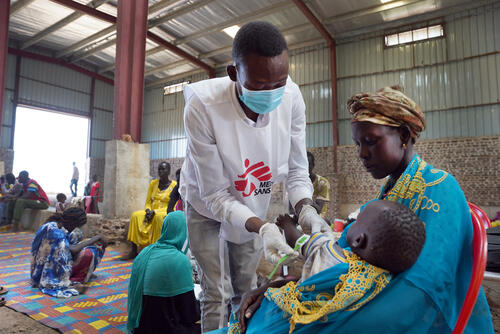 An MSF nurse aide Barnaba performs the MUAC measurement test on a child during a screening in an MSF mobile clinic at the Riverside transit site in Renk town, Upper Nile State, South Sudan.