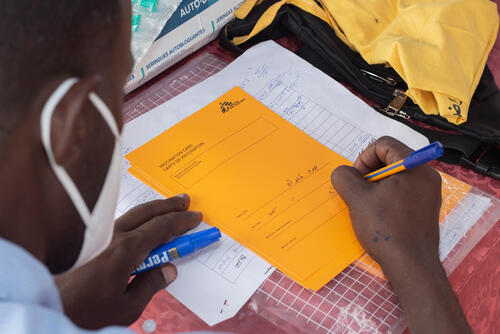 MSF staff signing a vaccination card for a patient who has received a measles vaccine in the Um Sangour camp, White Nile state, Sudan. Um Sangour camp is one of the ten camps in the White Nile hosting both refugees – mainly people who have fled from South Sudan – and internally displaced people fleeing from Khartoum and other parts of Sudan. The camps are in urgent need of scaled up assistance: by end of July 2023 the population of the camps had increased by almost half - from 290 000 refugees’ pre-conflict to 428 000 people. After an increase in suspected cases of measles, the Sudanese Ministry of Health started a measles vaccinations campaign on the 24 of August for children under five – supported by MSF. 

The vaccination campaign was essential and provided a big impact in reducing the spread of outbreaks, as many children are malnourished which if aggravated with measles can be a deadly combination. While the suspected measles is decreasing, children under 15 living in the camps and children in the outskirts of the refugee camp are without vaccination.