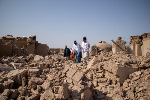 MSF staff walk over the rubble of what used to be people’s homes in Sanjaib Village, Injil District, Herat Province. The team is conducting an assessment of the population’s needs following the earthquakes in the province. All houses in the village were destroyed.