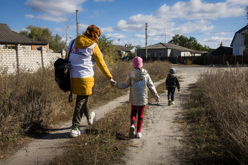 MSF psychologist Inna Suzova is seen with patient Inna Gladko’s young children. The psychologist accompanied the patient to school, after a therapy session, to pick up the children. The family receives psychological support from MSF. Little Dima is slowly recovering his speech. They now live in the northeastern Ukrainian city of Izium after it was retaken by the Ukrainian army.