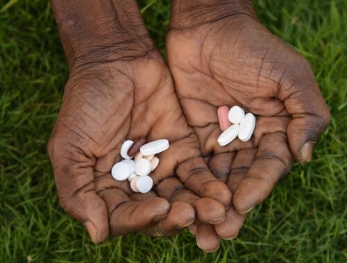 An MSF staff holding separate sets of the tuberculosis treatment medicine inside the Makeni Regional Hospital in Bombali District, Sierra Leone. The left hand contains pills from the BPaLM 6-month shorter regimen treatment and the right hand contains pills from the 18 months longer regimen treatment.  

MSF started rolling out the new BPaLM treatment in Bombali District, Sierra Leone, in November 2022, making this shorter treatment routinely available for patients diagnosed with drug-resistant tuberculosis (DR-TB).