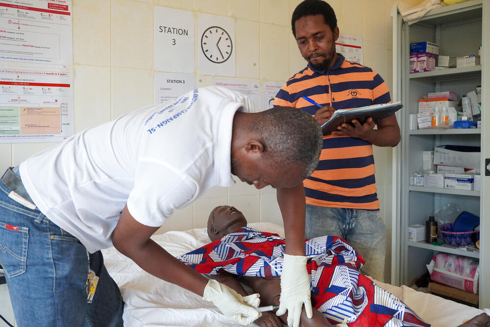 A nurse who participated in the Basic Clinical Nursing Care training programme of the MSF Academy for Healthcare is practicing IM injection on a manikin during his Competency Gap Assessment at the skills lab in Kenema hospital. The clinical mentor is assessing the level of competency.