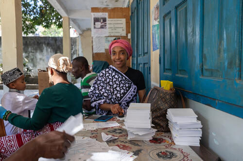 Member of the vaccination team stamping vaccination cards.