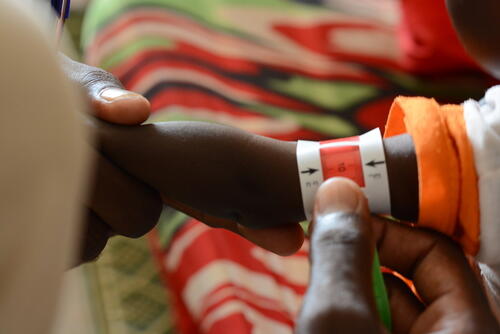 A child undergoes a MUAC screening in the ATFC at the MSF clinic in Zamzam Camp, North Darfur, a crucial step in diagnosing malnutrition.