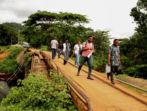 MSF staff crossing a wooden bridge, a short distance away from a primary healthcare facility MSF is supporting at Akor community in Akamkpa in Cross River state. The wooden bridge was constructed after the concrete bridge collapsed. It is now old too, so, MSF van must cross without passengers to reduce weight.