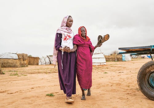 Health promoter Aisha B. (28) accompanies 80 years old Aisha G. to the MSF clinic in Adré transit camp, eastern Chad.