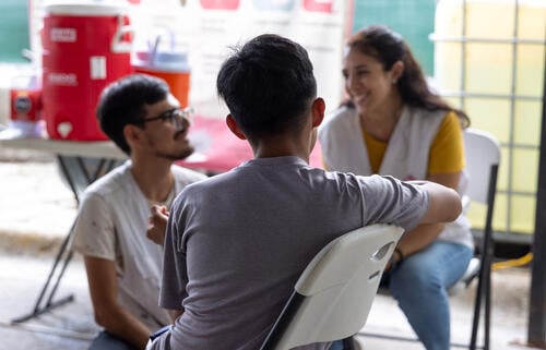 Two MSF staff chat with a child at the Pumarejo Shelter in Matamoros, a town in the northern Mexican state of Tamaulipas.