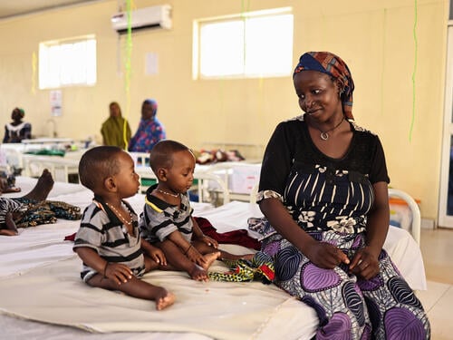 Binta Abdulraziqu sits beside her twin sons Hassan and Hussaini who were both admitted for severe acute malnutrition at the Inpatient Therapeutic Feeding Center in Maiyama Local Government Area, Kebbi State.