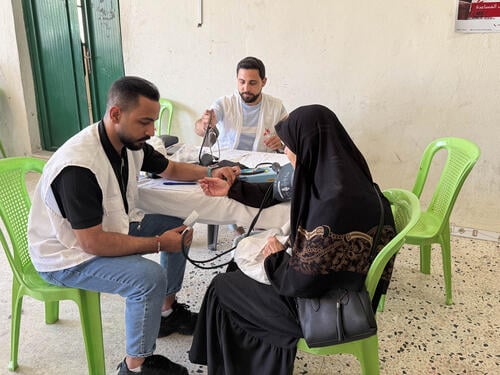 Nurses with MSF's mobile clinics in Nabatieh measure the vital signs of a member of the community.