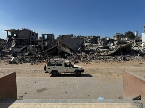An MSF vehicle is parked outside Al Rantisi Hospital in Gaza City, amidst the rubble and destruction in the area. The photo, taken from the hospital’s entrance, looks out onto the street.