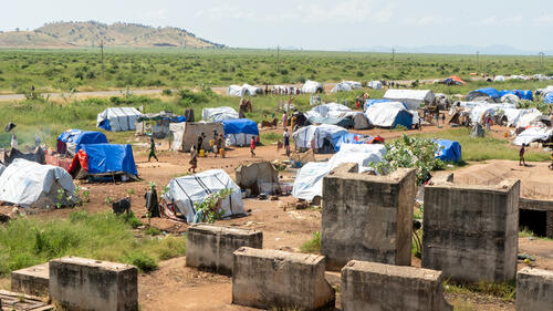 Concrete remains of the old mining factory, abandoned since the 2011 conflict, now stand surrounded by makeshift huts and families seeking safety.