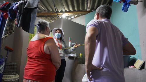 MSF health promoter explains to a family how to apply PPF discs