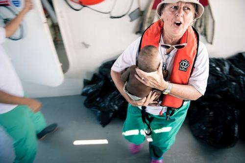 Australian nurse Carol Nagy rushes a 8 month old Nigerian baby to the clinic on the MY Phoenix