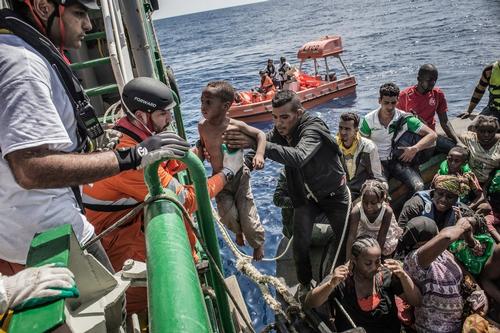 26th August 2015. A young child is lifted from a boat containing approximately 650 people during a rescue in the Mediterranean Sea by the Bourbon Argos.