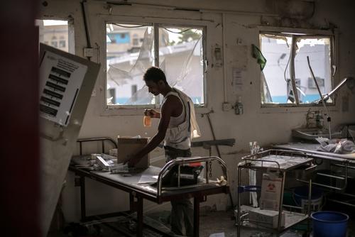 A hospital worker salvages the remains of undamaged medication and equipment left in the emergency room after the 15 August Saudi-led coalition airstrike which destroyed the hospital killing 19. 

In a country where access to healthcare is already extremely limited, the Abs hospital was the only facility catering to over 2,000 IDPs in the area and thousands more along the coast, from the northwestern border of Yemen to the outskirts of Hodeidah. With the destruction of Abs hospital, the closest hospital is now over 3 hours drive away.