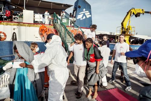 Oct. 24, 2016. Oussama Omrane, a cultural mediator for MSF, helps a Nigerian woman, who was saved off the Libyan coast by the MSF search and rescue vessel the Dignity I, to disembark. The Dignity I arrived at the port of Trapani, in Sicily, Italy, on Oct. 24, 2016, with 548 people of different nationalities on board, who had been saved off the Libyan coast.