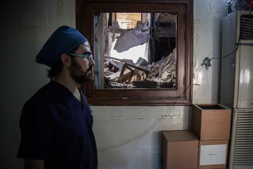 Dr Abu Wasim, a plastic surgeon, stands next to a damaged ward on the upper floors of a hospital in east Aleppo after it was hit by an airstrike in mid-October 2016. He is one of the 7 surgeons left in East Aleppo.