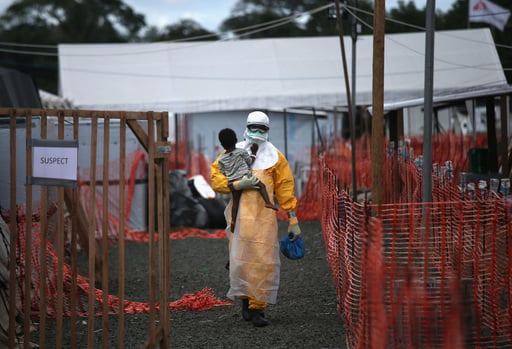 PAYNESVILLE, LIBERIA - OCTOBER 05:  A Doctors Without Borders (MSF), health worker in protective clothing carries a child suspected of having Ebola in the MSF treatment center on October 5, 2014 in Paynesville, Liberia. The girl and her mother, showing symptoms of the deadly disease, were awaiting test results for the virus. The Ebola epidemic has killed more than 3,400 people in West Africa, according to the World Health Organization.  (Photo by John Moore/Getty Images)