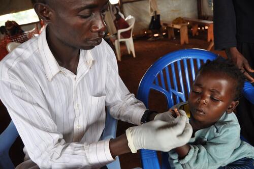 b)	Billy`s symptoms are typical of malaria, which is often characterised by a fever, headache, joint pains, vomiting and other flu-like symptoms. Saidi Lukozi, MSF Nurse Assistant at Nyarugusu camp, therefore tests Billy for the disease. Billy receives a small pin-prick to her finger to extract a drop of her blood, which is then tested immediately, on-site, to see if malaria parasites are present. 
This kind of testing is the most reliable way of diagnosing malaria in the camp`s remote and basic environment: little training is needed in order to administer the tests; no additional laboratory equipment is required; and the results are fast and simple to interpret.