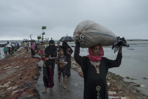People in the rain at a border crossing on the Naf river, near Teknaf, September 19.