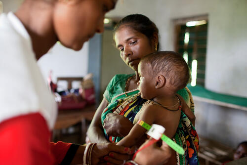 16 month old Somai Soya is checked for malnutrition with a MUAC as he and his mother