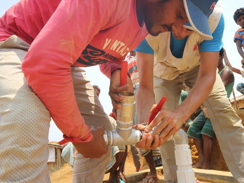 Arafat Hosen (left), an MSF Water and Sanitation (Watsan) Network Distribution Supervisor, and Thibault Chazal, MSF Watsan Manager, lead the installation of a submersible pump in a deep well in the Kutupalong-Balukhali Rohingya refugee camp, April 18, 2018. MSF has provided hundreds of hand pumped wells and drilled 25 deep bore holes for motorised pumps, bringing over 32 million litres of water to the camp so far. The provision of safe drinking water in the camp is as much a life-saving priority as medical care.