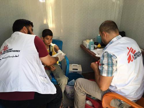 MSF staffs treat a young boy in a mobile clinic that provides services for displaced Syrians. Idlib, Syria.