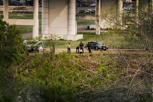 This sequence shows a couple of migrants trying cross the width of the Rio Bravo river, in front of the Eagle Pass International Bridge, where USA border police intercept them in the middle of the channel.
