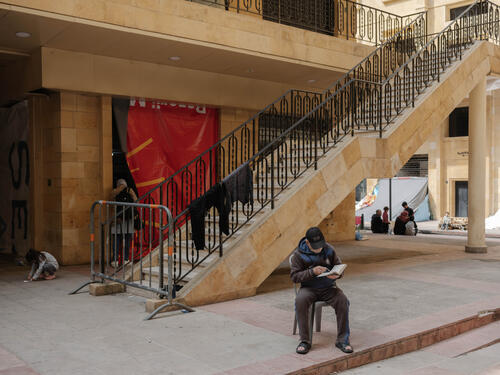 Lebanon, Beirut, 2026. A man reads book in the Azarieh in central Beirut, where displaced families took shelter in an abandoned building.

With over a million people registered as displaced, Lebanon is facing a deepening humanitarian crisis. Thousands have fled their homes under threat of fire - often with nothing.